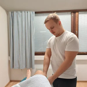 Hannes tekee jalkahierontaa asiakkaalle kotikäynnillä Joensuun seudulla.